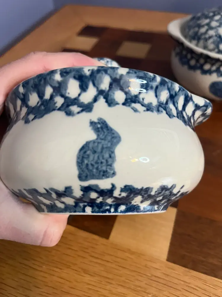 Two Tienshan Sponge Blue individual casseroles with lids, featuring folk art motifs. One Features A Cow The Other A Bunny, Both Have Hearts.
5” Diameter - 4” High With lid