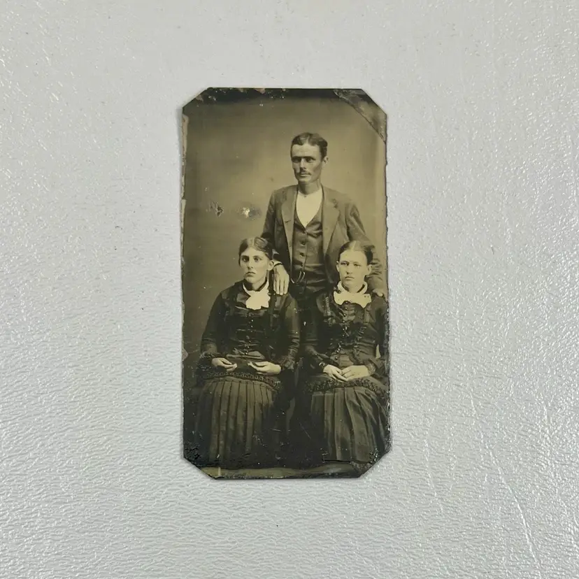 Antique Tin Tintype Photo Family Portrait Two Women Matching Dresses And Man 3.25x1.75"