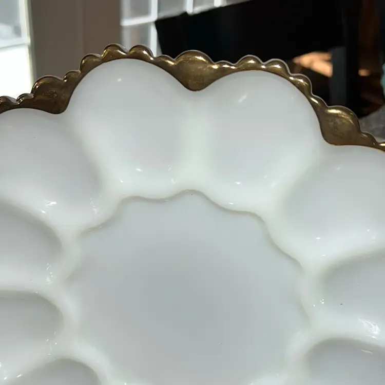 This is a vintage Anchor Hocking milk glass deviled egg plate with gold trim.