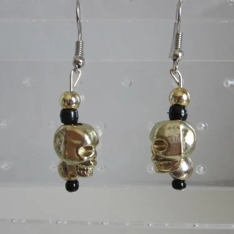 Gold metal skull earrings with beaded accents