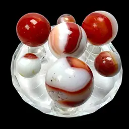 7 Marbles (4 are 1” Shooters) & 3” Clear Crystal Sphere Holder. Cadmium🧡 Orange Glow & Yellow-Green 💛💚On Some Marbles Under UV Black light.