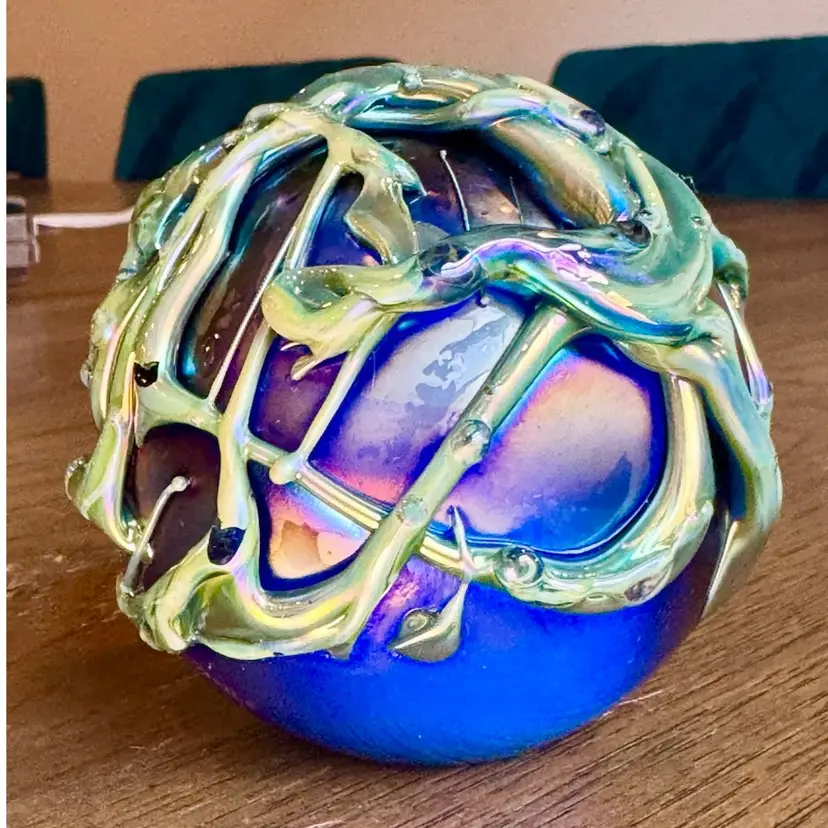 3” iridescent studio art glass paperweight. The "HAT" initials referring to the unique external glass trailing that sits on the orb