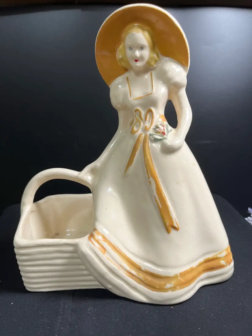 USA #954-Pottery Southern Lady w/ Gold Bonnet & Gold Tone Accents on Dress, Holding a Flower in One Hand & an Oversized Basket in the Other