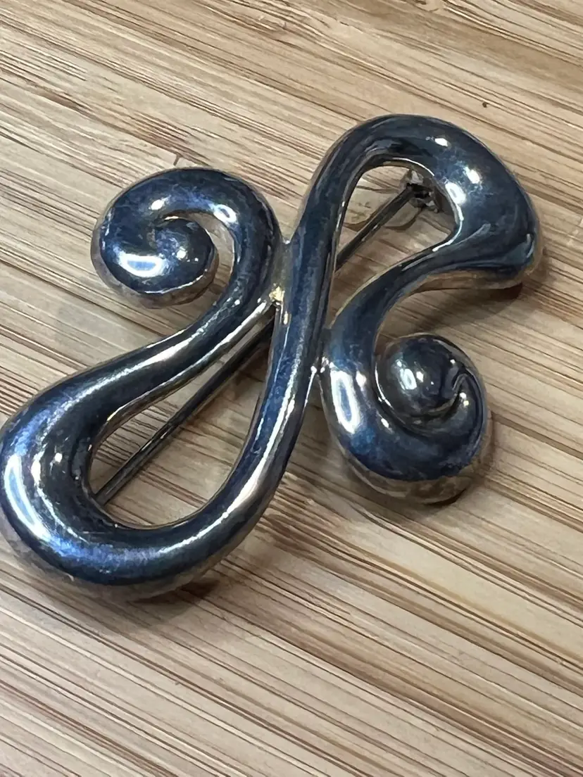 Vintage Carolee signed silver swirl infinity brooch.