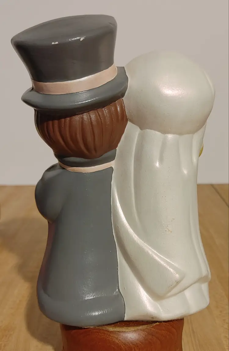 Bride and Groom. Ceramic. About 7.5 high. 2 tiny spots on back of hat.