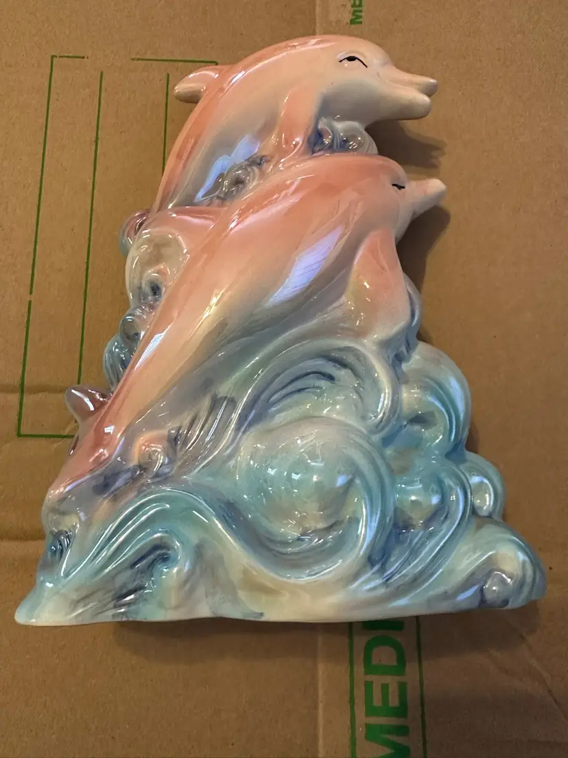 Porcelain figurine of dolphins leaping through waves.  Approximately 12” Tall