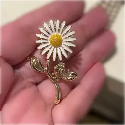 29. White enamel Daisy on gold tone brooch.