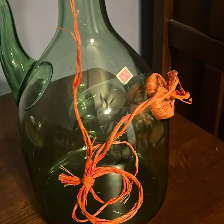 Vintage hand-blown green glass decanter with ice chamber and decorative twine. - Sticker States Made In Italy.
 Bottle is 13 inches high
From Edge Of Spout To Edge Of Bottle Is 8 Inches .