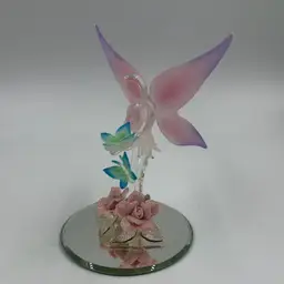 Vintage Glass Baron Art Glass Fairy With Pink And Purple Wings Holding A Green And Blue Butterfly Standing On 2 Glitter Pink Ceramic Roses.
