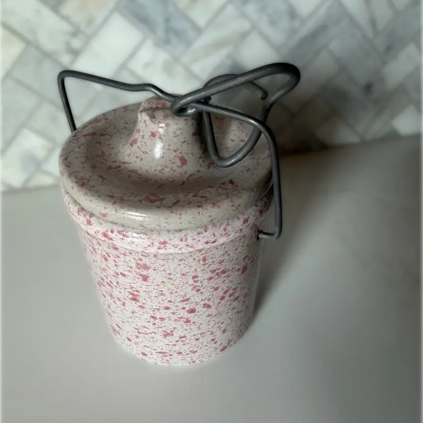 A vintage speckled pink and beige ironstone cheese crock with wire handle. Circa 1920-1940
