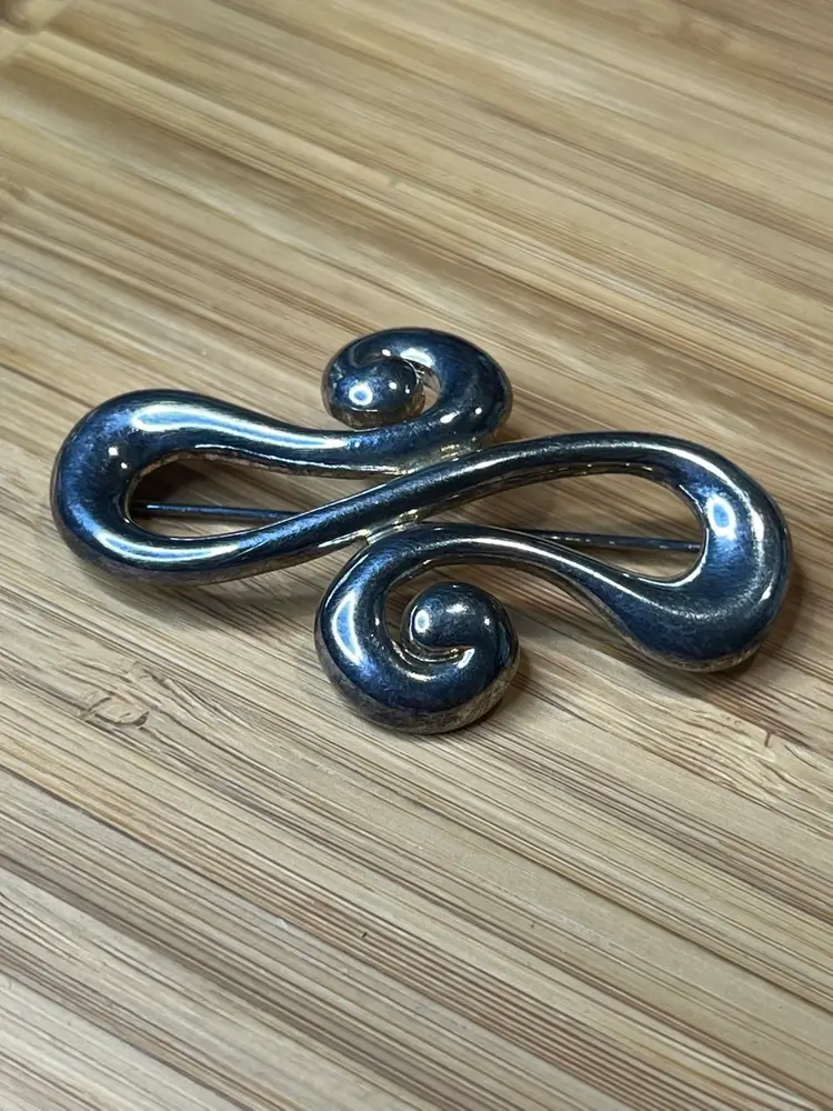 Vintage Carolee signed silver swirl infinity brooch.