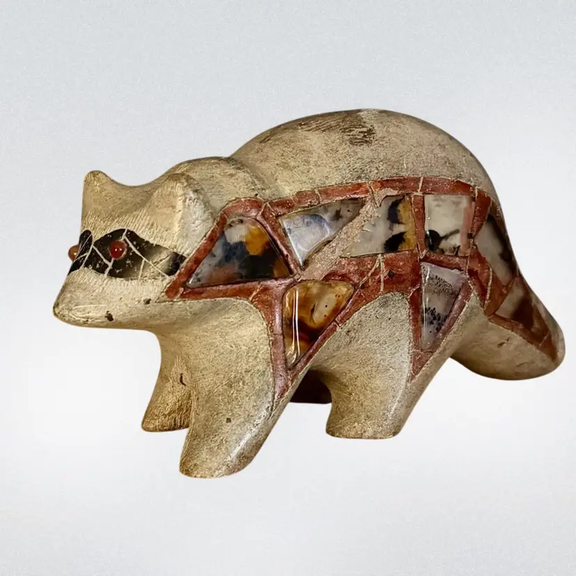 1983 Craved Stone Raccoon Figurine Adorned With Inlaid Stone Tiles & Eyes Tan/Rust/Black Artist Tsonakwa #1591.
3-3/4” T x 7-1/4” L x 2-3/8” W