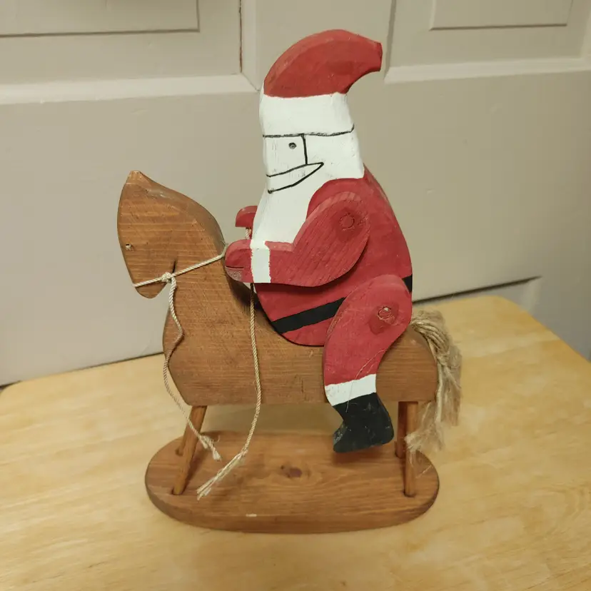 Santa on wood rocking horse. Primitive looking. 11.5 inches high. 1 hand is chipped.