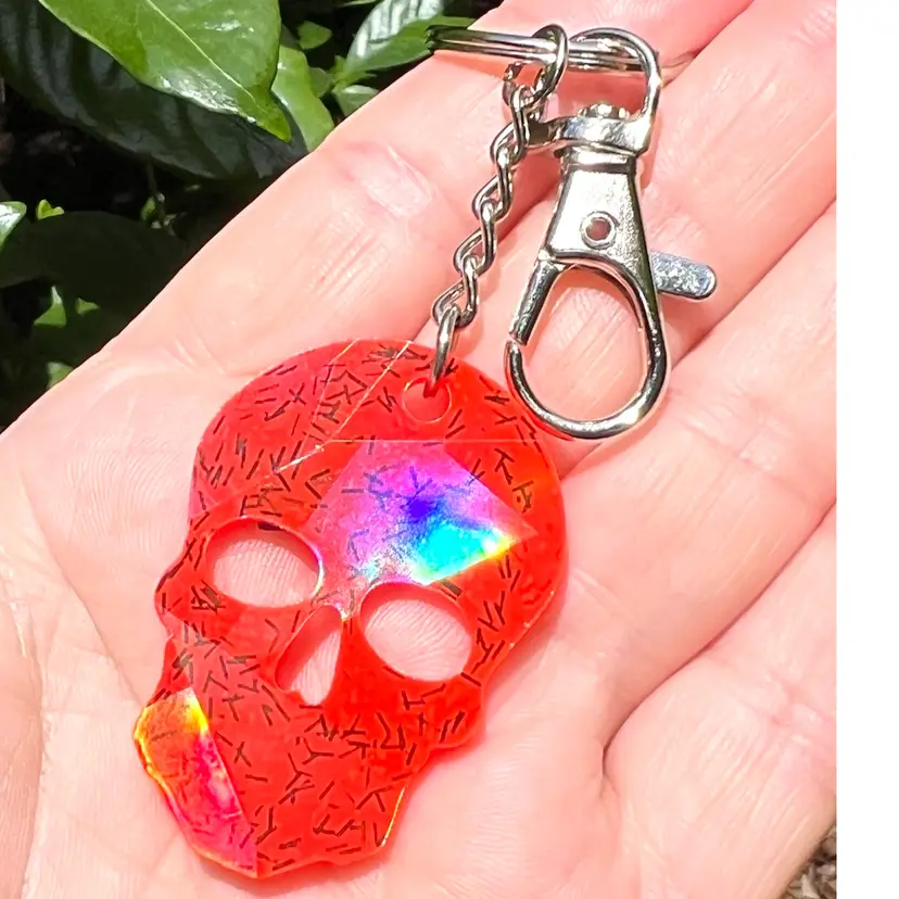 Orange Holographic Skull 💀 Resin 5” Keychain / Bag clip. Handmade By Me 🫶. Fluorescent-Glows Under UV ! Perfect For Halloween.
