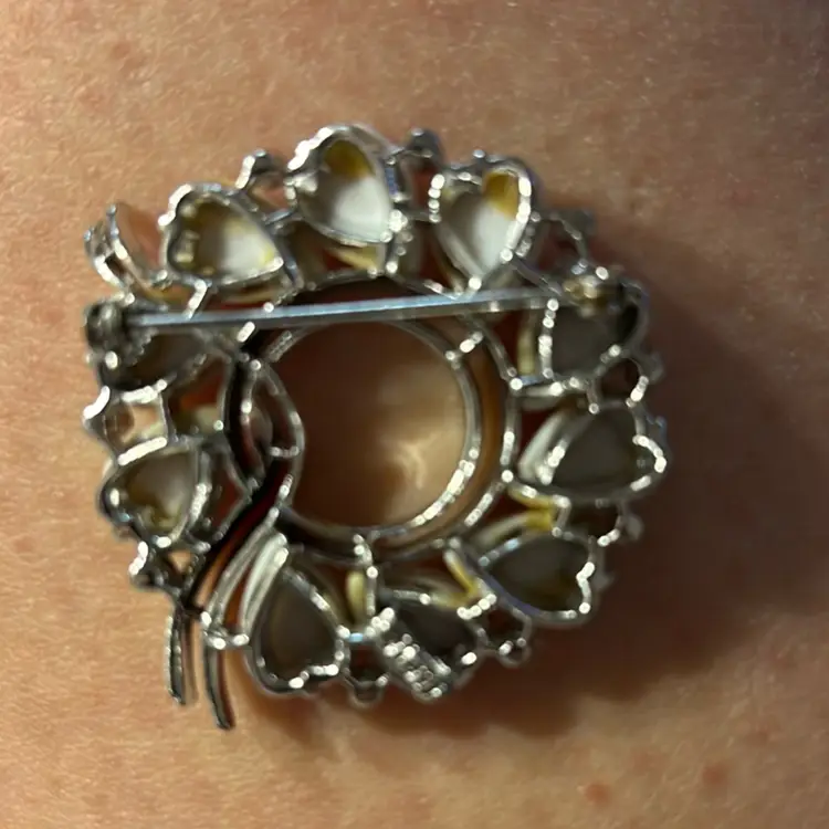 #01 Vintage Lisner Silver Tone Circular White Thermoset Heart Shaped Open Center With Tiny Rhinestones And Silver Tone Like Ribbon Running Thru Middle.