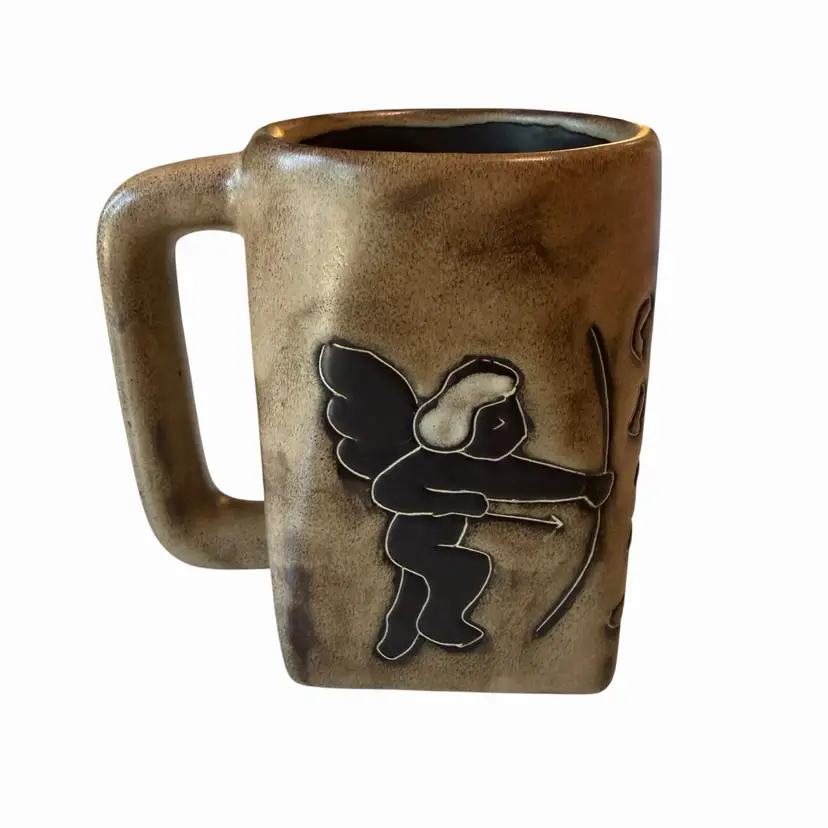 Mara Mexico handcrafted stoneware mug features a unique rectangular shape with a tan glaze and a black Cupid graphic