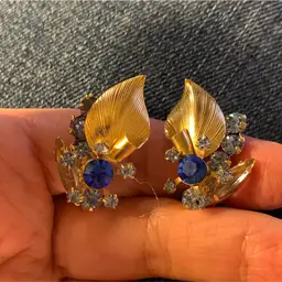 Juliana Gold Tone Clip On Earrings Gold Metal Textured Leaf, Dark Blue Circle Rhinestone Surrounded By Lighter Blue Chitons