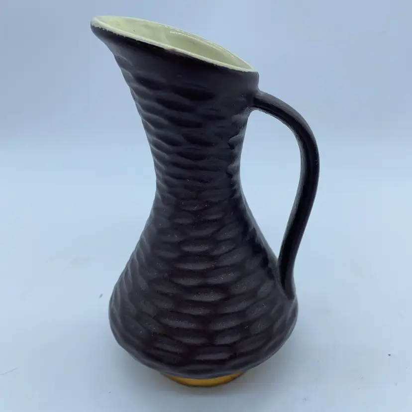 #2256 A textured West German art pottery pitcher (model 925) with a metallic base and a minor chip.