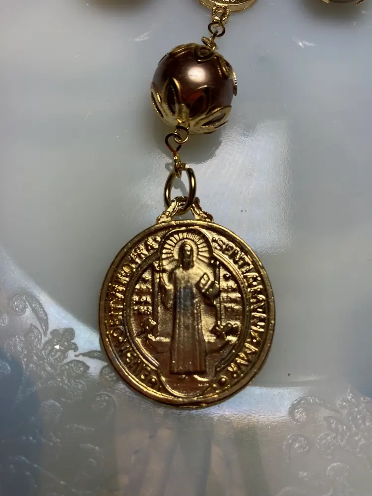 Bracelet Rosary
Large Metal Bronze Tone Beads with Ornate Brass Covers.  
Brass Crucifix & Jesus. 
Lobster Clasp. 
They Call It A Bracelet Rosary But It Seems Bigger Than a Bracelet. 
Collectable