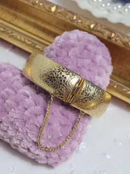 Vintage goldtone bangle bracelet with floral etching safety chain