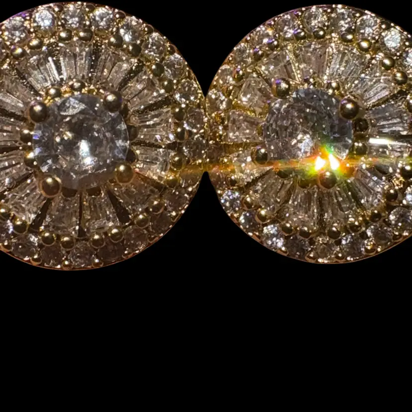 These earrings feature a classic round halo design crafted in yellow gold plating.