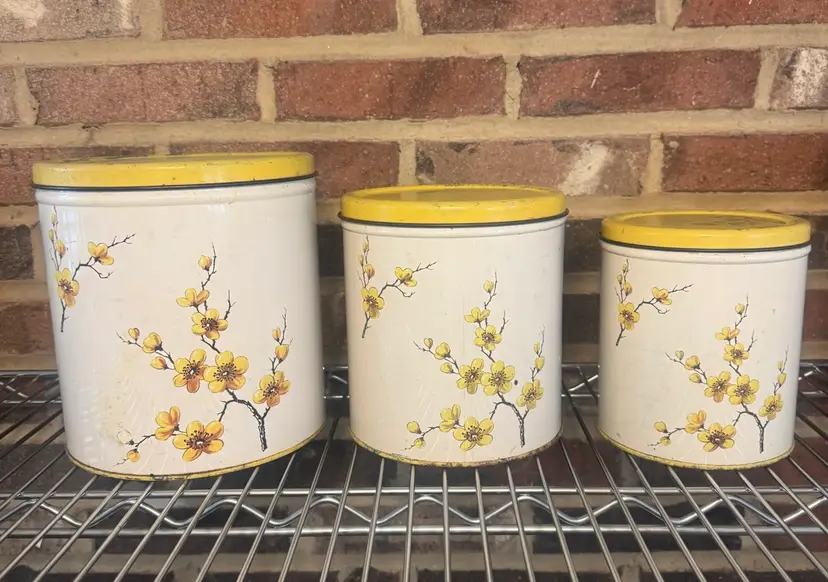 Vintage 1950’s Metal Decoware Nesting Canister Set Of 3. Gorgeous Vintage Wear Adds Their Charm! Yellow Floral W/Yellow Kids. 8”, 7”, 6”.