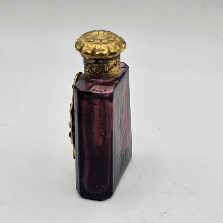 Purple Glass Perfume Bottle With Ornate Metal Design And Colored Rhinestones And Stopper