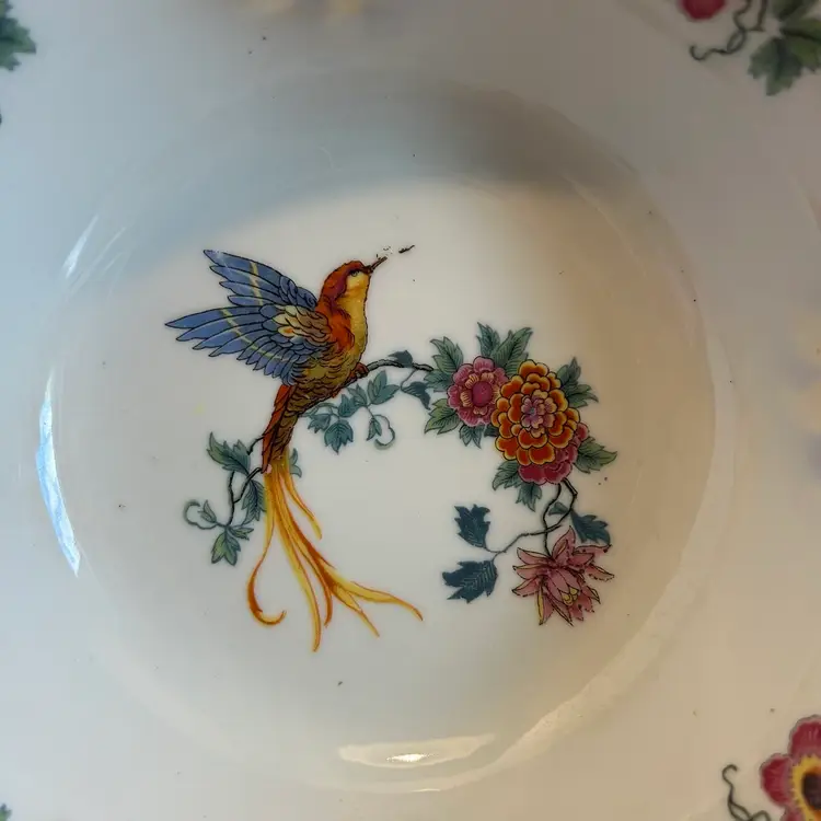 The Vintage Schwarzenhammer Bavaria Hummingbird Serving Bowl is a stunning piece of porcelain art from the mid 20th century. 

Featuring a beautiful Art Nouveau style with a glossy finish and a decorative floral pattern, this 9" round bowl is perfect for serving at all occasions. 

Made in Germany, this original piece showcases intricate details of a hummingbird design, adding a touch of charm to your table setting.   

Hand wash only to preserve its vintage beauty.