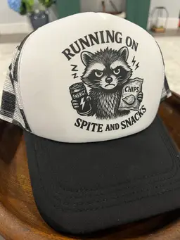 Running on Spite And Snacks Raccoon Trucker Hat