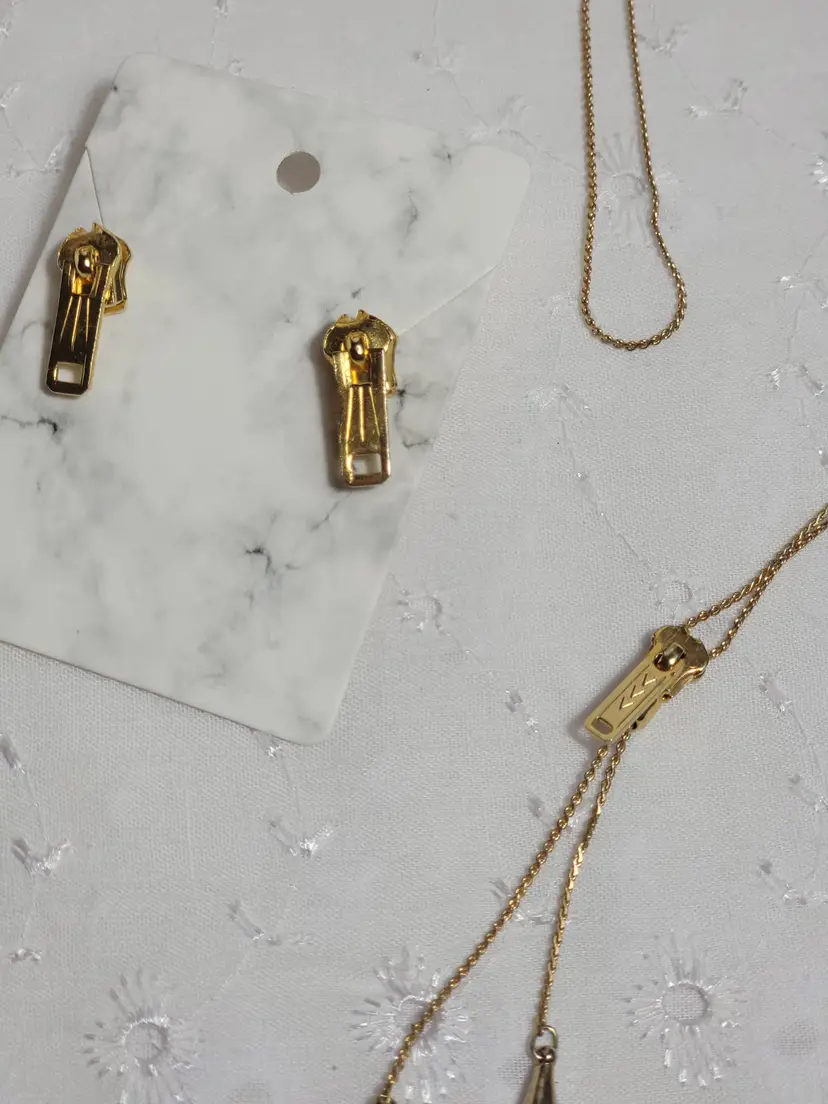 A goldtone Zipper necklace and earring set