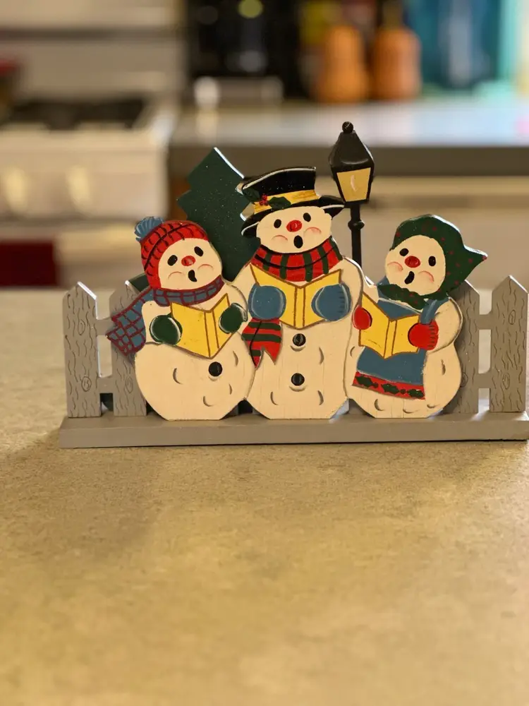 Wooden Christmas decoration featuring caroling snowmen figurines