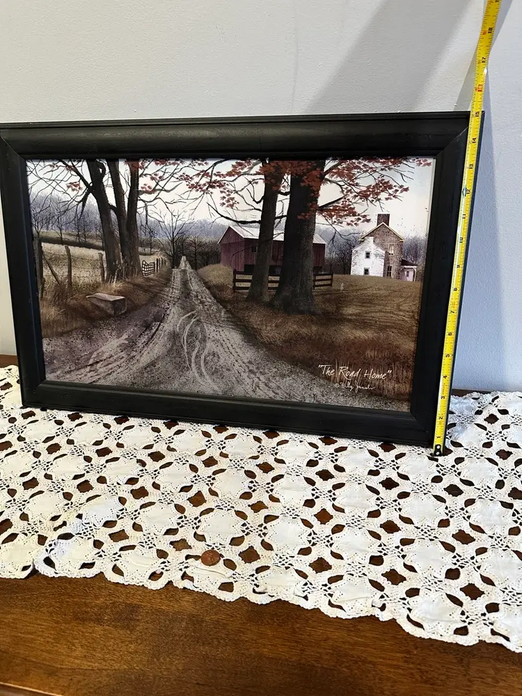 Framed print titled "The Road Home" by artist Billy Jacobs. The artwork depicts a country landscape with a dirt road leading toward a red barn and a white farmhouse. Approx. 22”x 15” Excellent condition