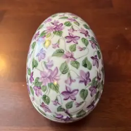 Vintage Norcrest porcelain egg-shaped trinket box with violet floral pattern.