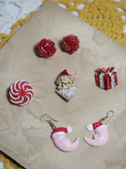 Lot of Christmas earrings a couple small brooches and a signed Avante Santa brooch