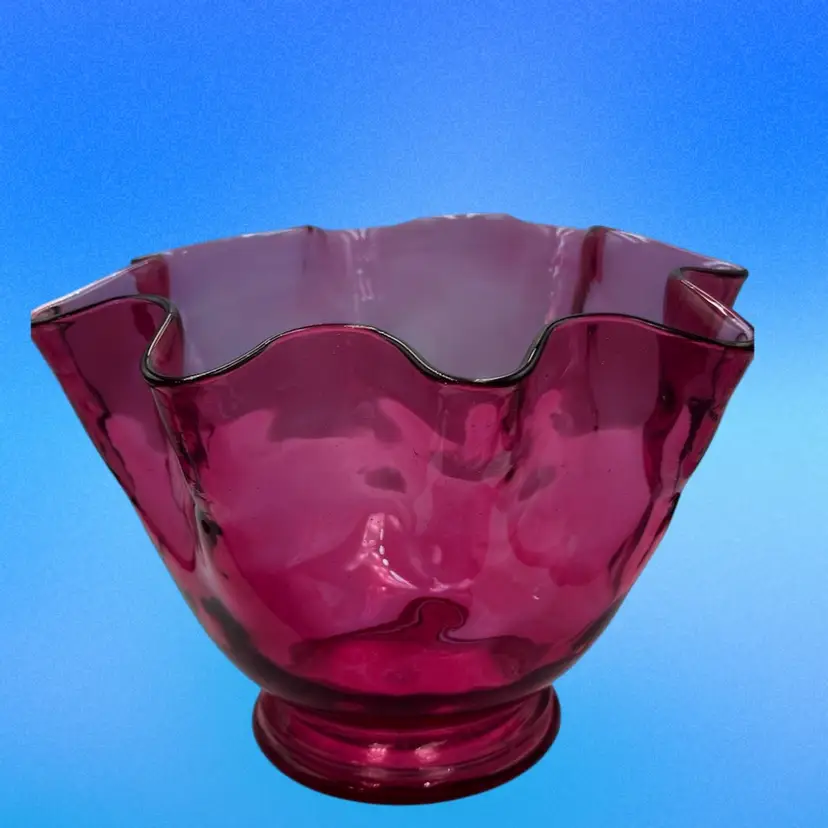 A12 Cranberry glass bowl with a ruffled edge and pedestal base
