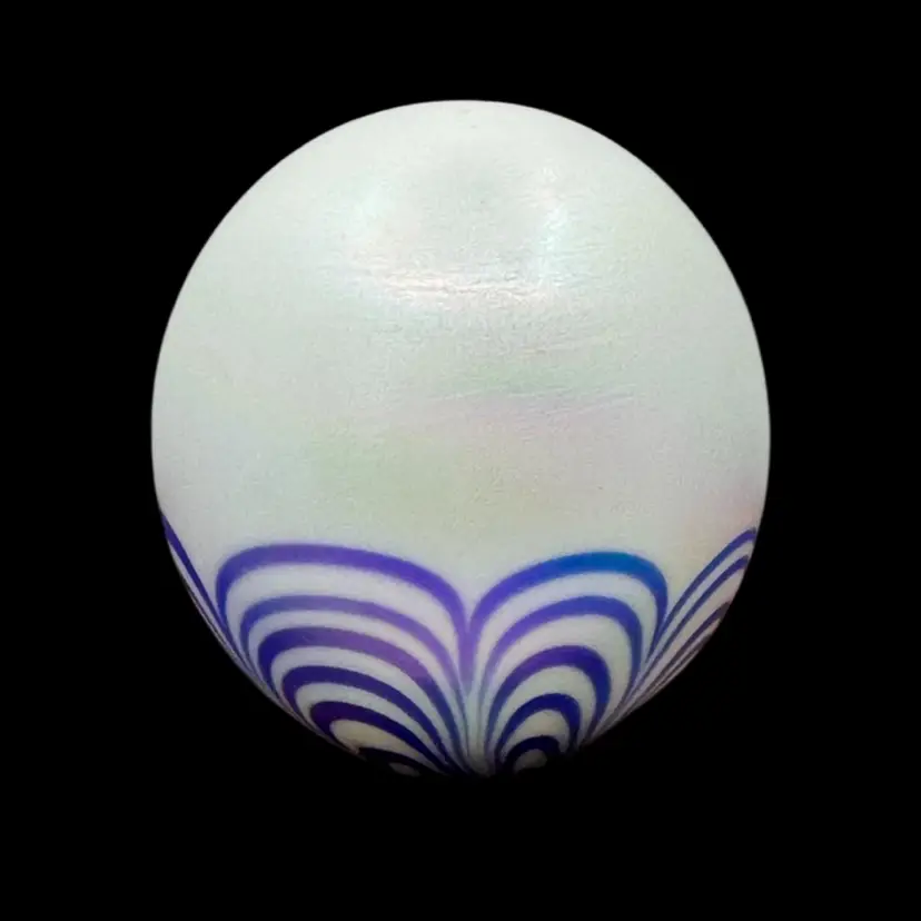 Vintage pearlescent art glass paperweight with blue and purple pulled feather design.