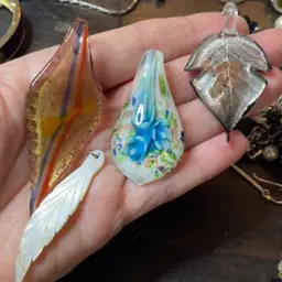 Four pendants three glass, one mother of pearl