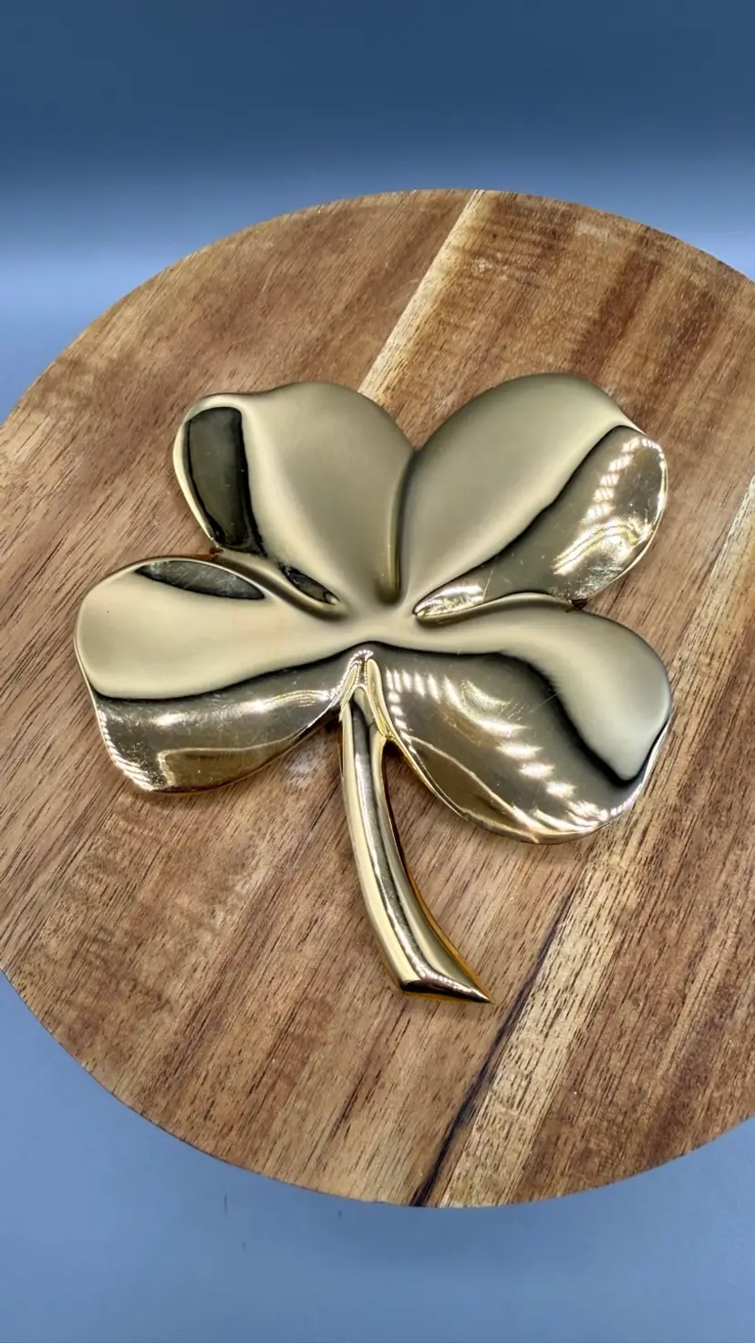 Vintage 1984 Gerity 24K Gold Plated 4-Leaf Clover Paperweight Wall Plaque this beautiful 1984 Gerity four-leaf clover. This versatile piece features a high-shine 24-karat gold electroplated finish and can be used as a desktop paperweight or as a wall-hanging plaque using the original wire clip on the reverse side. 4.25" x 4.25