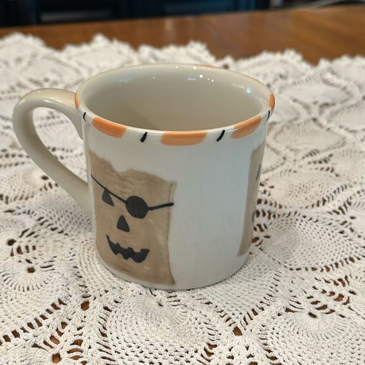 Vintage Starbucks Barista Hartstone Halloween mug. The mug is 14 oz and features a hand-painted design of paper bag jack-o'-lanterns with a candy corn striped rim. The mug is made of heavy ceramic and was produced exclusively for Starbucks in the USA.