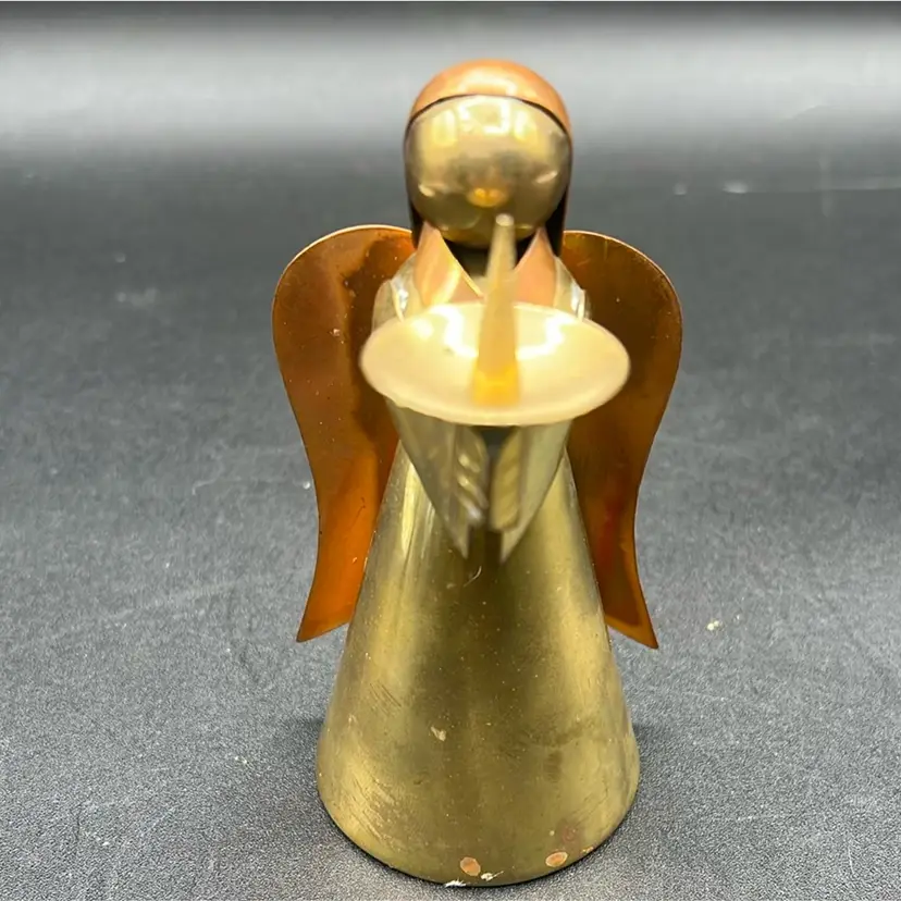 Vintage angel candle holder, likely handmade from brass and copper, often associated with holiday decor and Mexican craftsmanship.