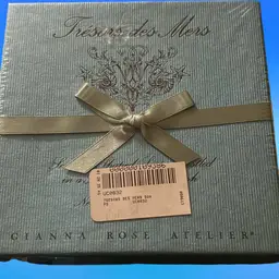 New, Sealed Package, boxed gift set of four seashell soaps by Gianna Rose Atelier. 
The set includes a large, polished abalone shell that serves as a soap dish.The soaps are ecru-colored and shaped like seashells.
They come in two scents: oatmeal and a light floral scent.Great Christmas Gift Idea