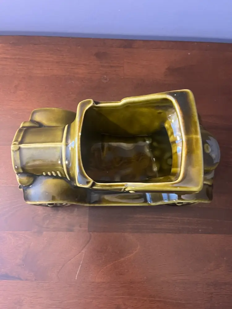 A vintage McCoy pottery olive green ceramic Model T car planter. 9” L 4” H