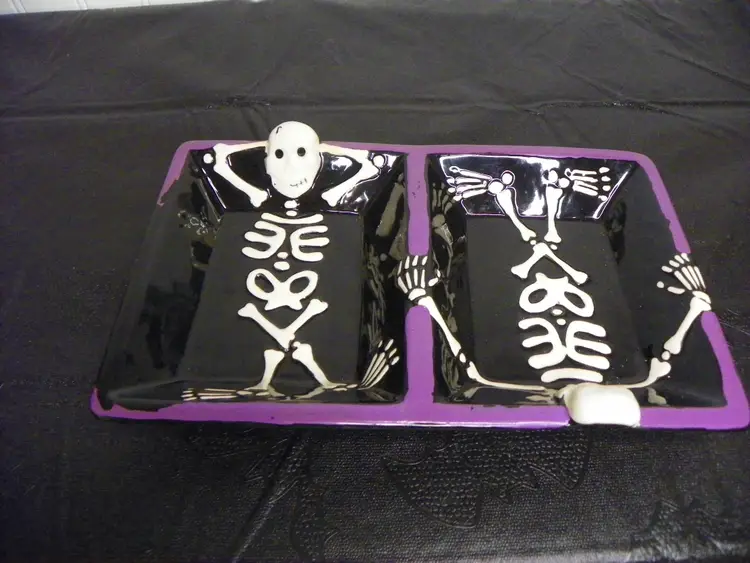 Halloween decorative candy dish featuring two skeletons