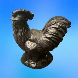 A handcrafted black rooster figurine made from coal.3”