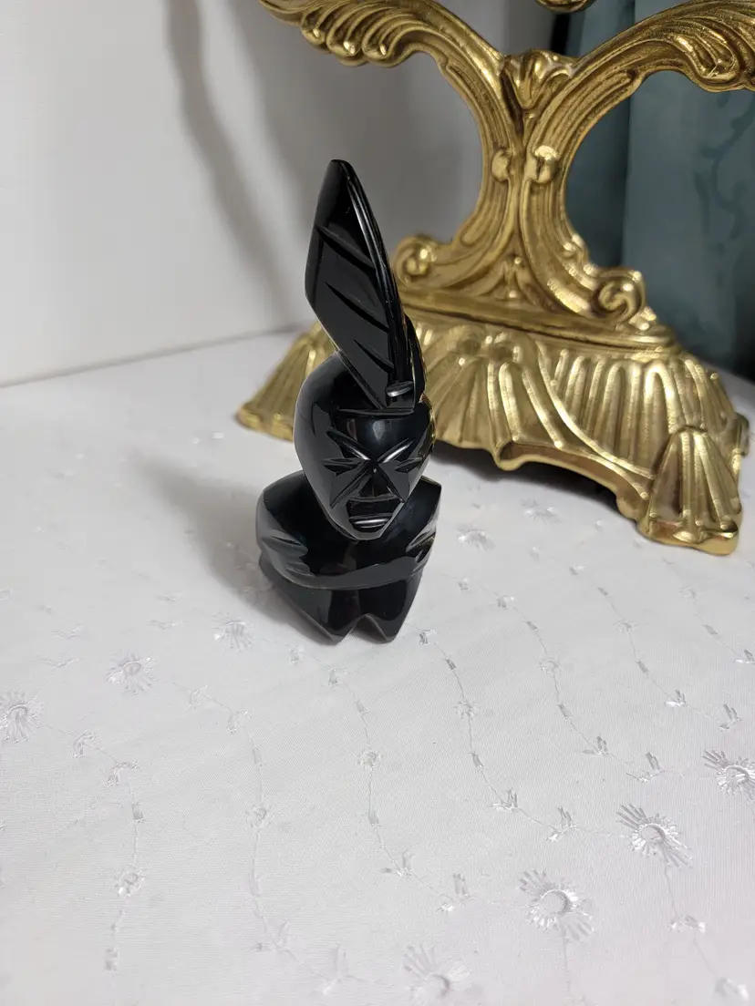 Vintage carved black stone figurine likely made of obsidian