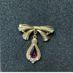 1928 Gold Tone Bow Brooch Purple Glass Drop With Rhinestones