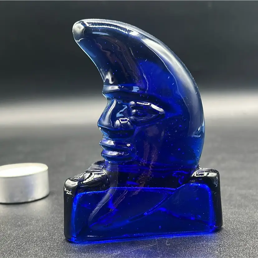vintage cobalt blue glass celestial candle holder featuring a "man in the moon" face design.
