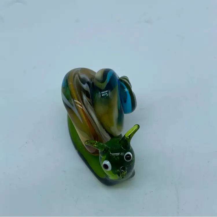 Hand-blown glass snail figurine with green body and swirled shell.