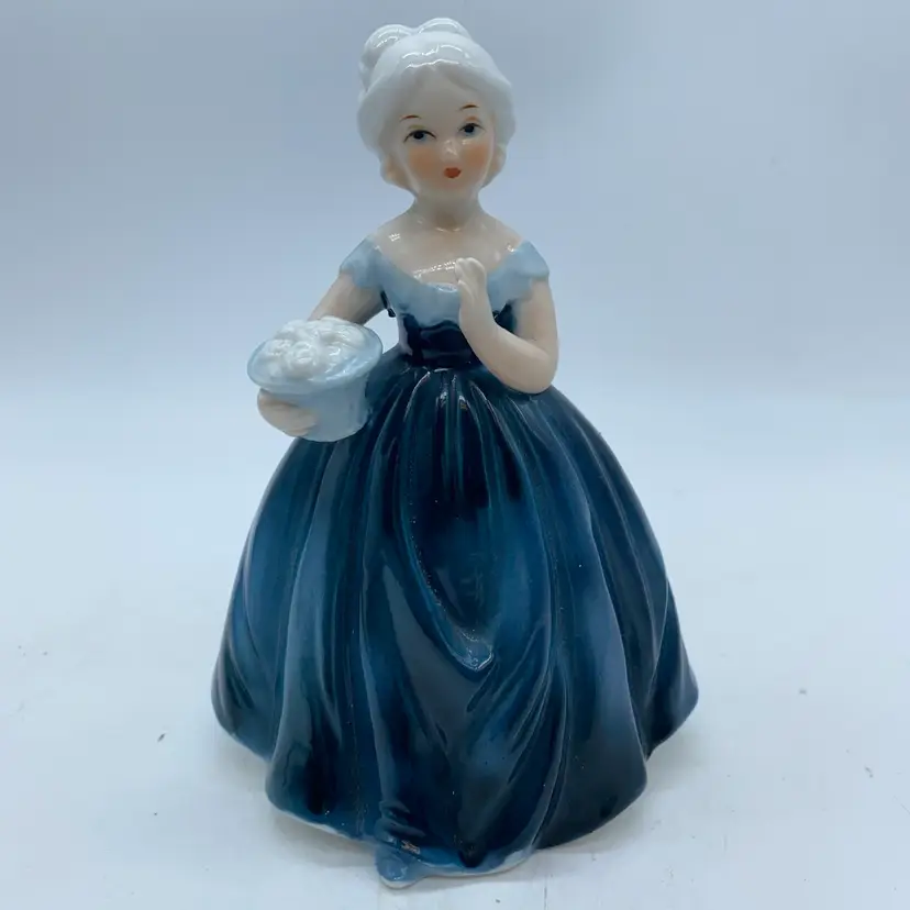 #1445 decorative porcelain figurine of a woman holding flowers, made in Taiwan.