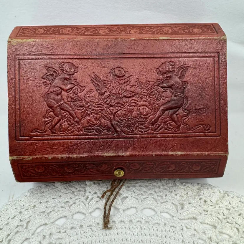Leather Like Covered Box With Cherubs And A Snap Closure, Likely From Late 1800-early 1900’s, 3”x8”